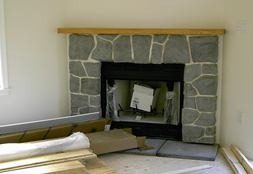 CORNER GAS FIREPLACE WITH STONE SURROUND AND FLUSH HEARTH